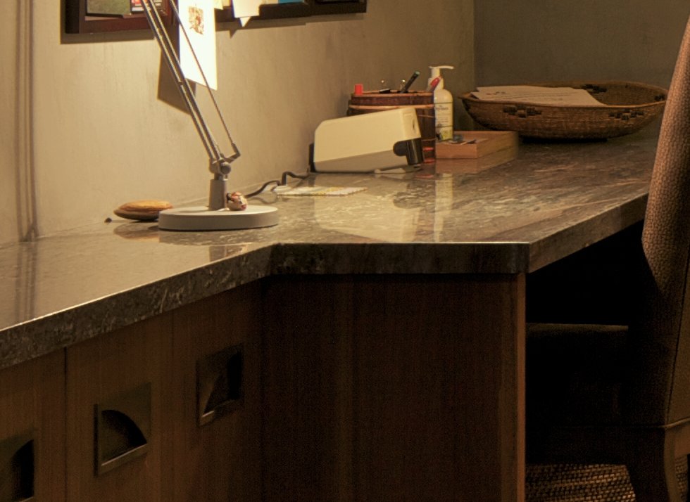 Detail of a task lamp and walnut cabinetry at a built-in desk